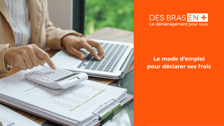 Un couple, assis devant une grande grille de contrôle française des impôts, étudie des documents fiscaux sur une table entourée de cartons de déménagement.