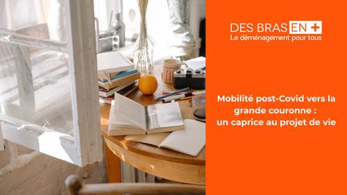 Une table placée devant la fenêtre entrouverte où sont étalés des livres et des pièces de vaisselle.